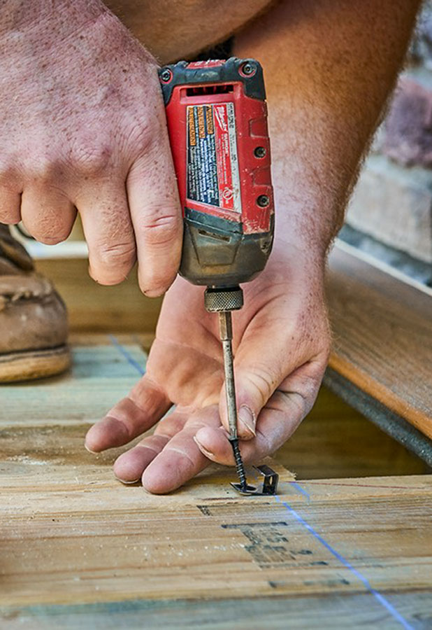 starter clip being screwed into joist